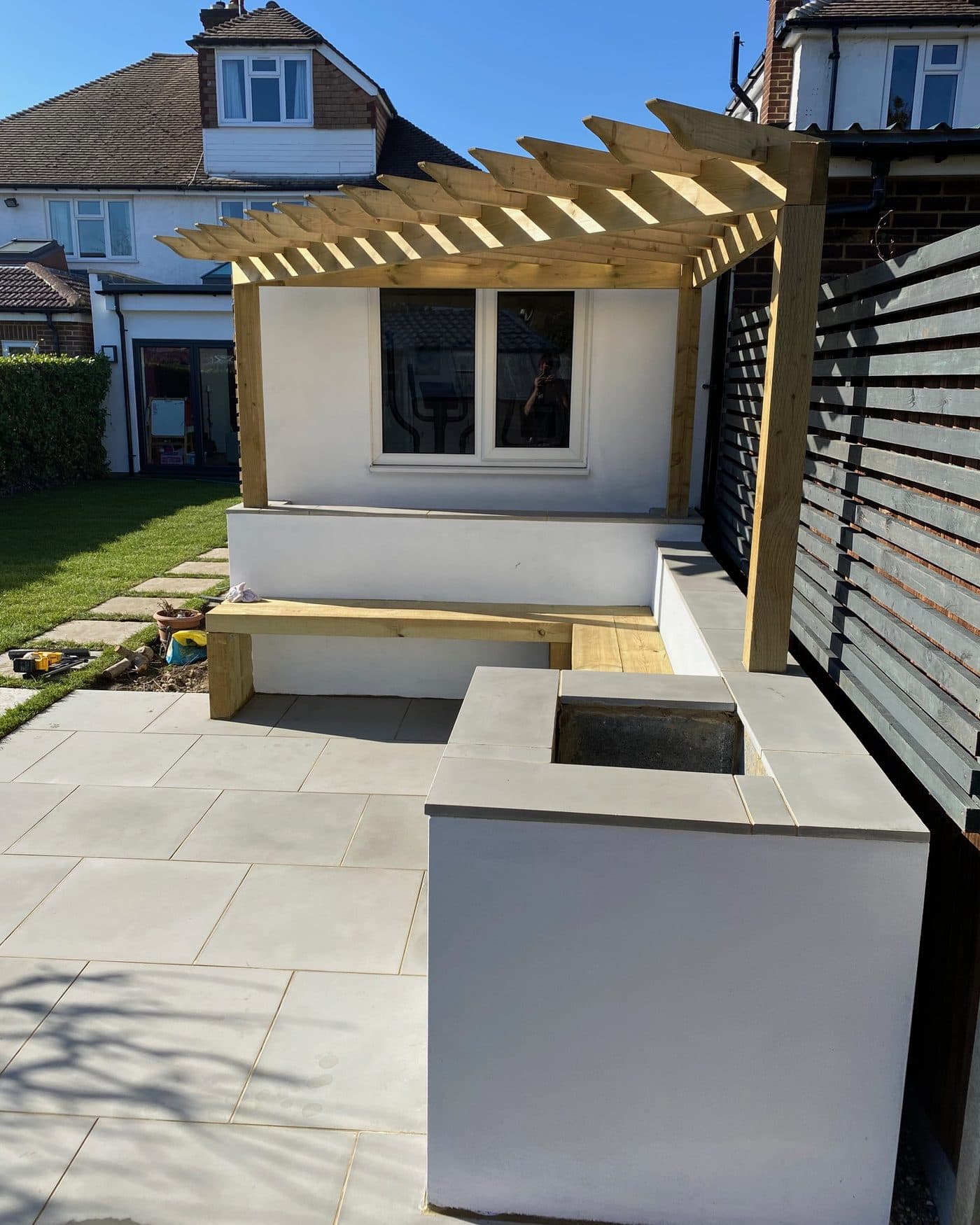 Bespoke pergola courtyard with rendered seating, fire table and slatted screen